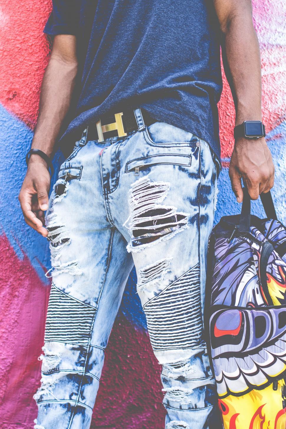 Free Image of Fashionable man standing against graffiti wall 