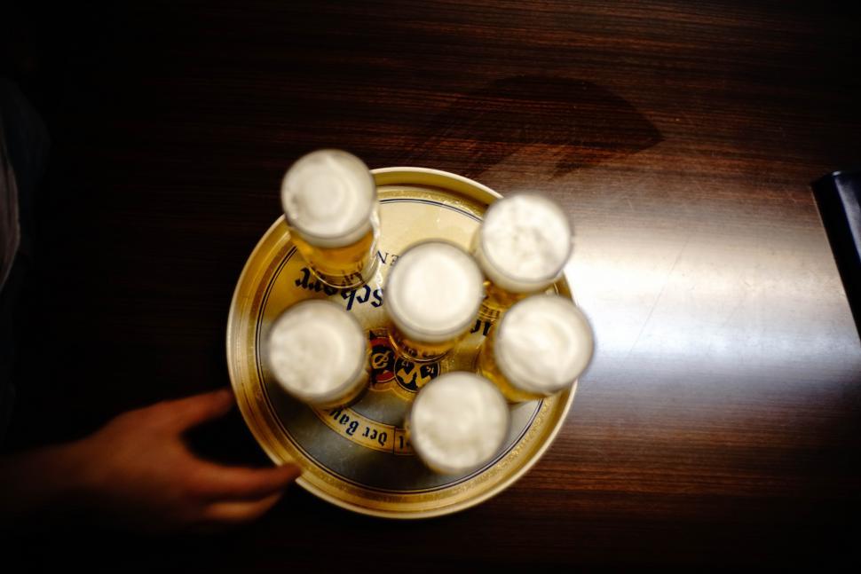 Free Image of Beer glasses with hand on wooden table 