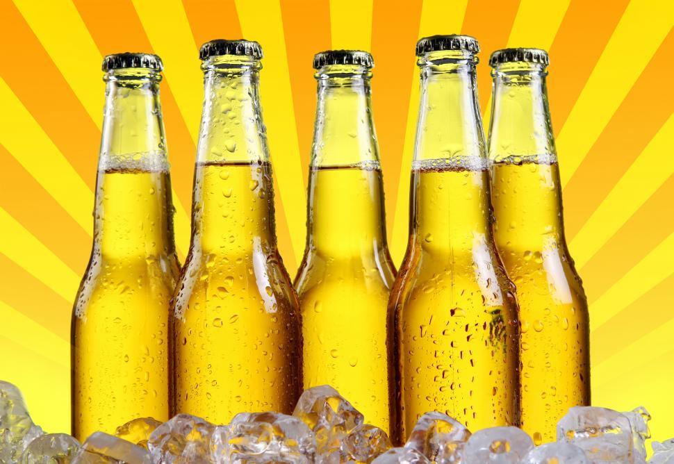 Free Image of Bottles of beer with abstract burst graphic background 