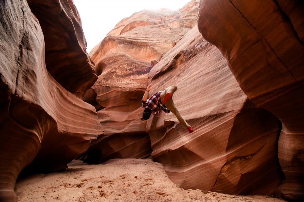 Free Image of Man jumping on textured rock stones in the cave 