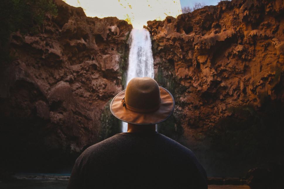 Free Image of Back side view of male hiker with mountain waterfall 