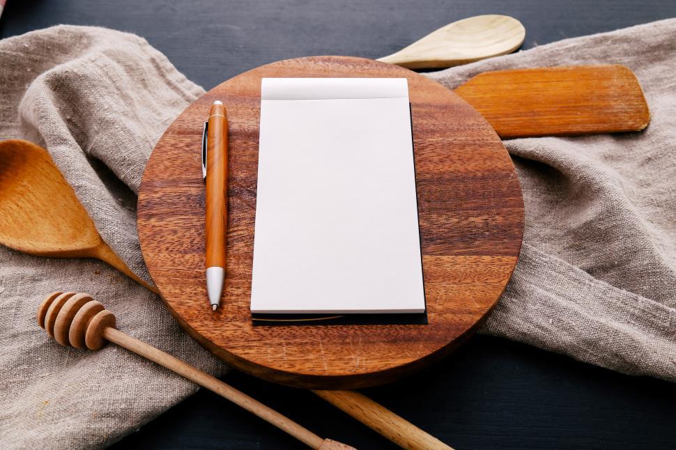 Free Image of Blank notebook with pencil on wooden cutting board 