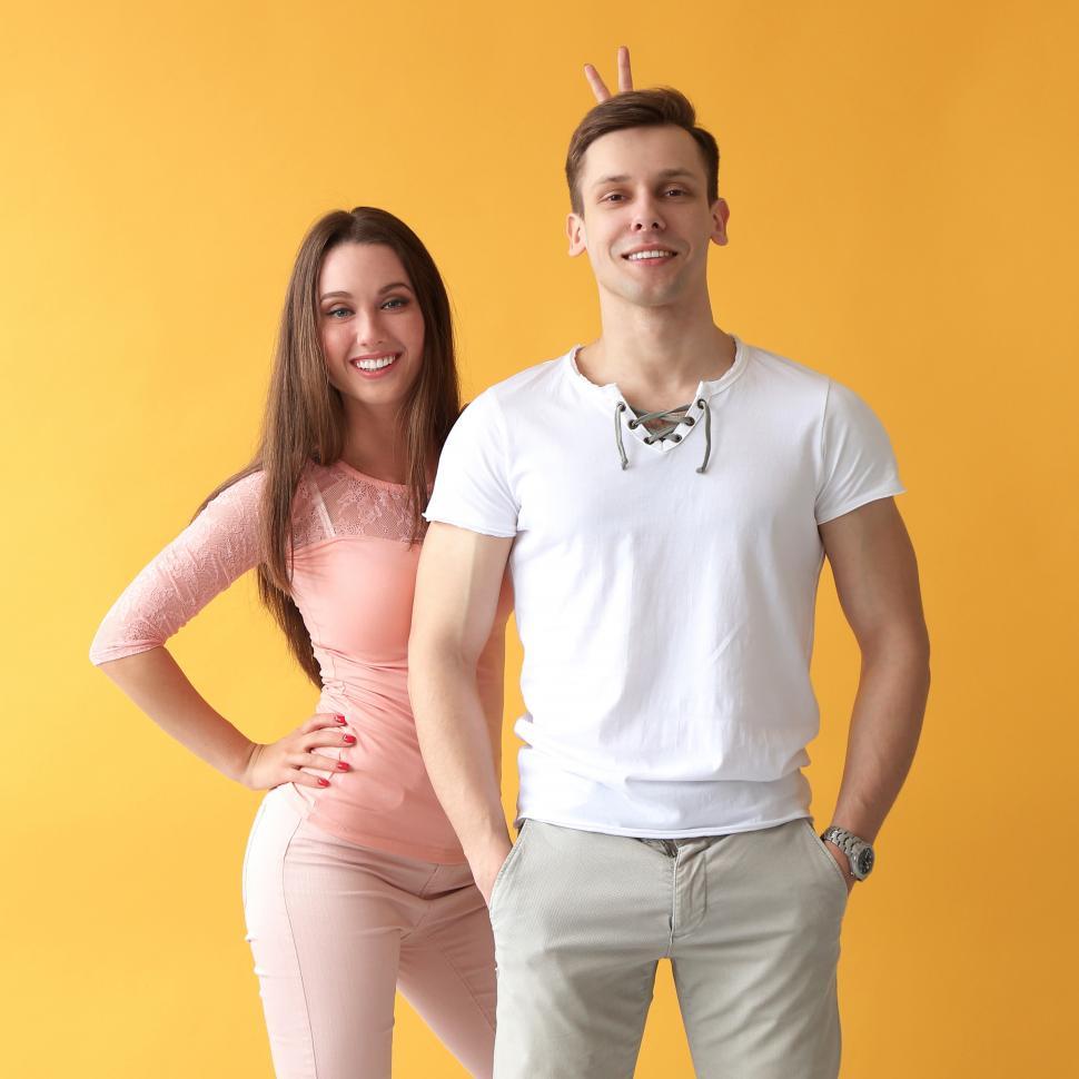Free Image of Young woman gives rabbit ears to her man 