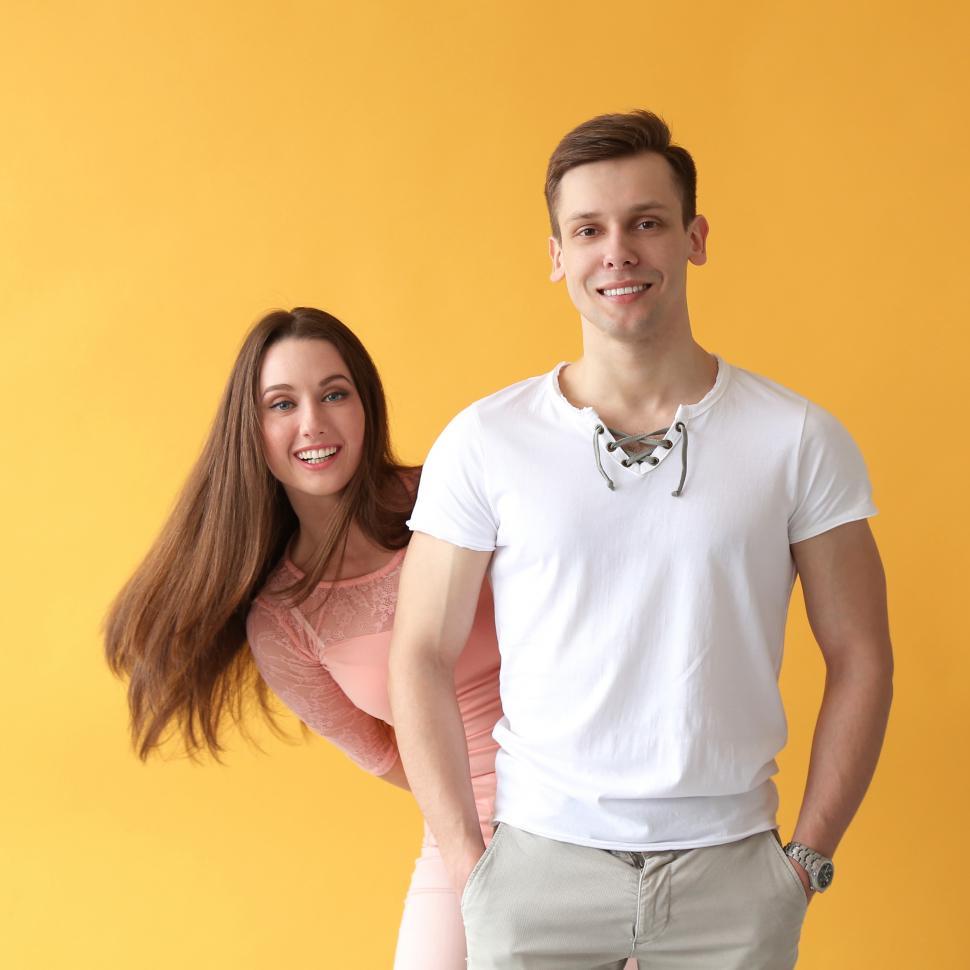 Free Image of Playful young couple, yellow background 