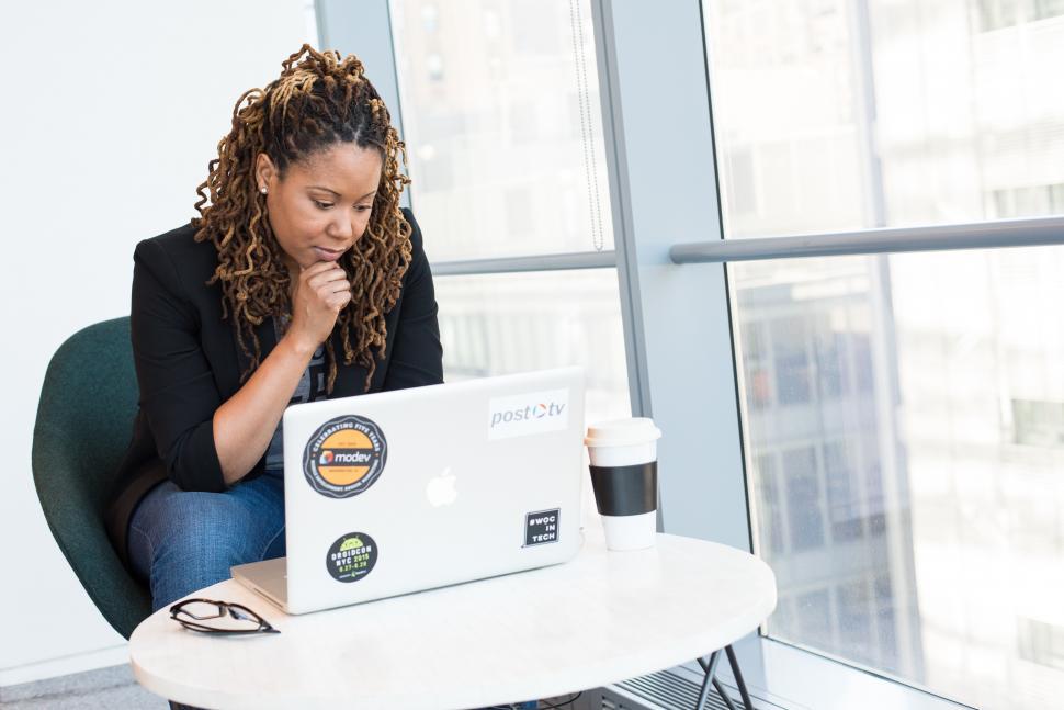 Free Image of Female programmer with laptop and disposable coffee cup 