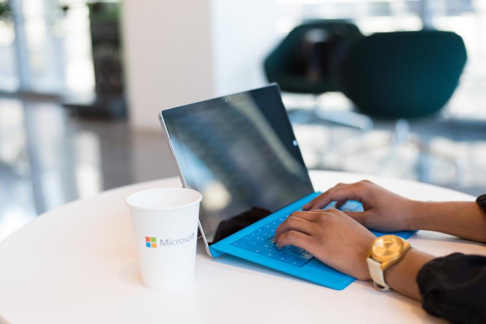 Free Image of Hands typing on blue laptop 