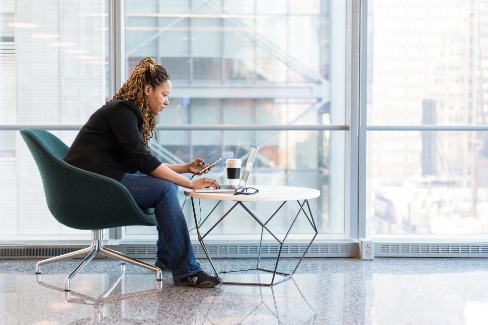 Free Image of Female programmer using laptop with disposable coffee cup 