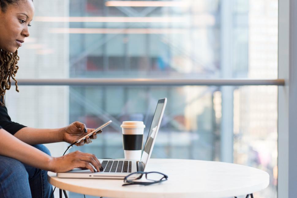 Free Image of Female programmer using laptop with disposable coffee cup on tab 