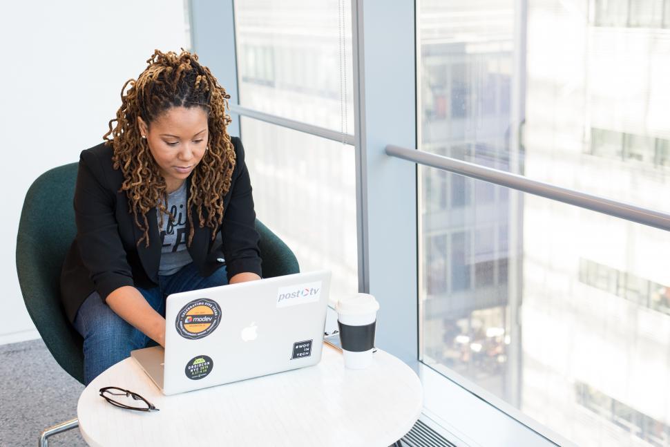 Free Image of Female programmer with laptop and disposable coffee cup 