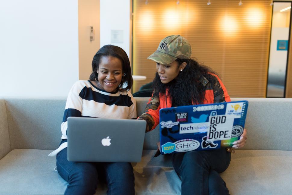 Free Image of Happy businesswomen with laptops on couch 