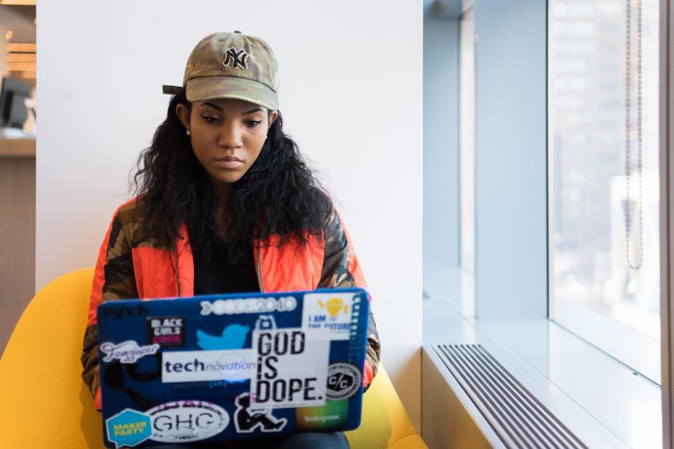 Free Image of Stylish woman sitting with laptop near window in office 