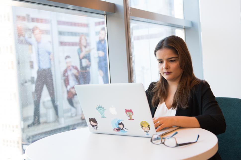 Free Image of Businesswoman working on laptop in office - looking down 