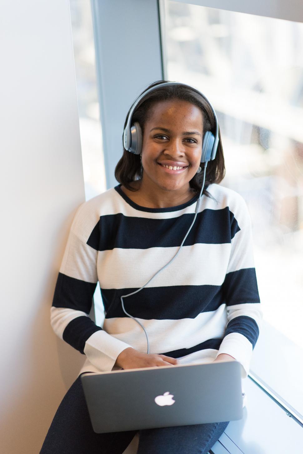 Free Image of Female using laptop with headphones in room 