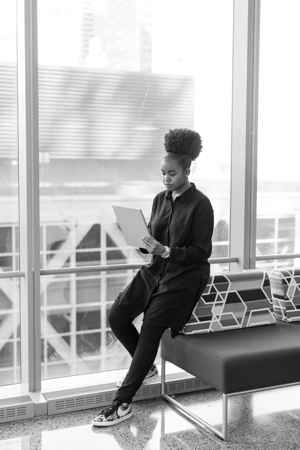 Free Image of Woman with tablet computer near glass window in office - b&w 