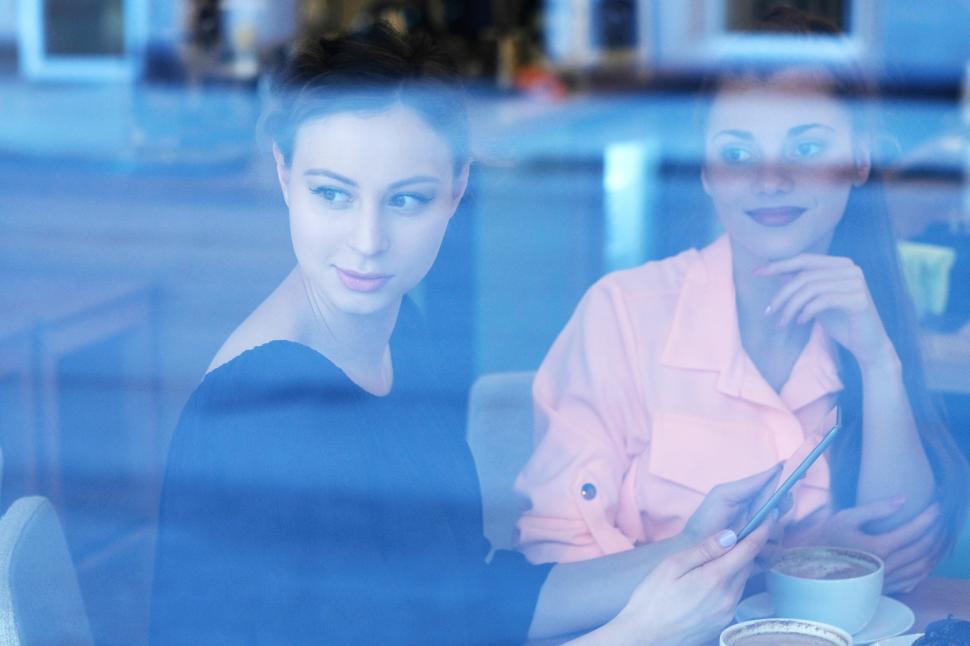 Free Image of Women in cafe with friend, looking out the window 