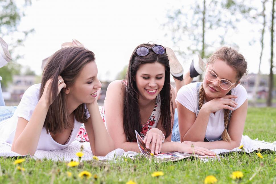 Free Image of Friends lounge on a blanket in the park 