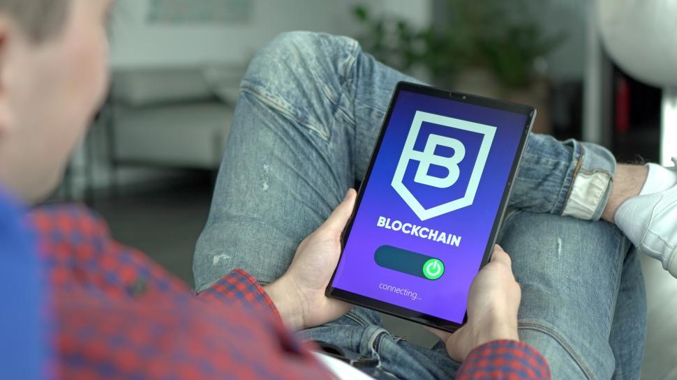 Free Image of Man Holding Cell Phone With Blockchain Logo 