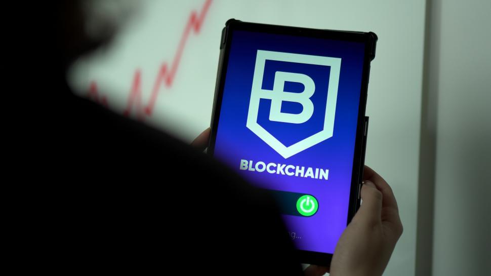 Free Image of Person Holding Cell Phone With Blockchain Logo 