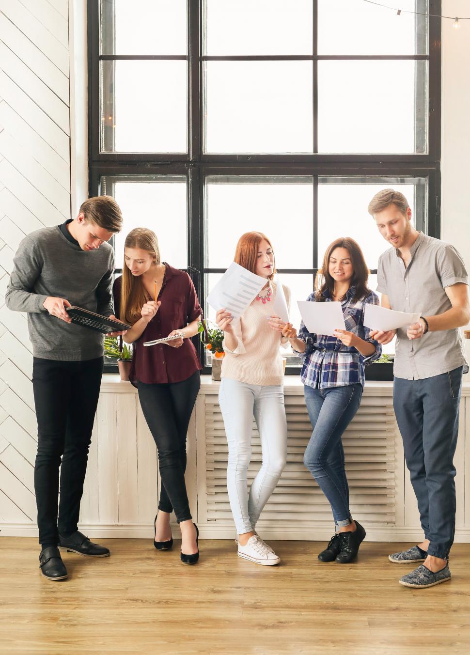Free Image of People in the office gather by the window 