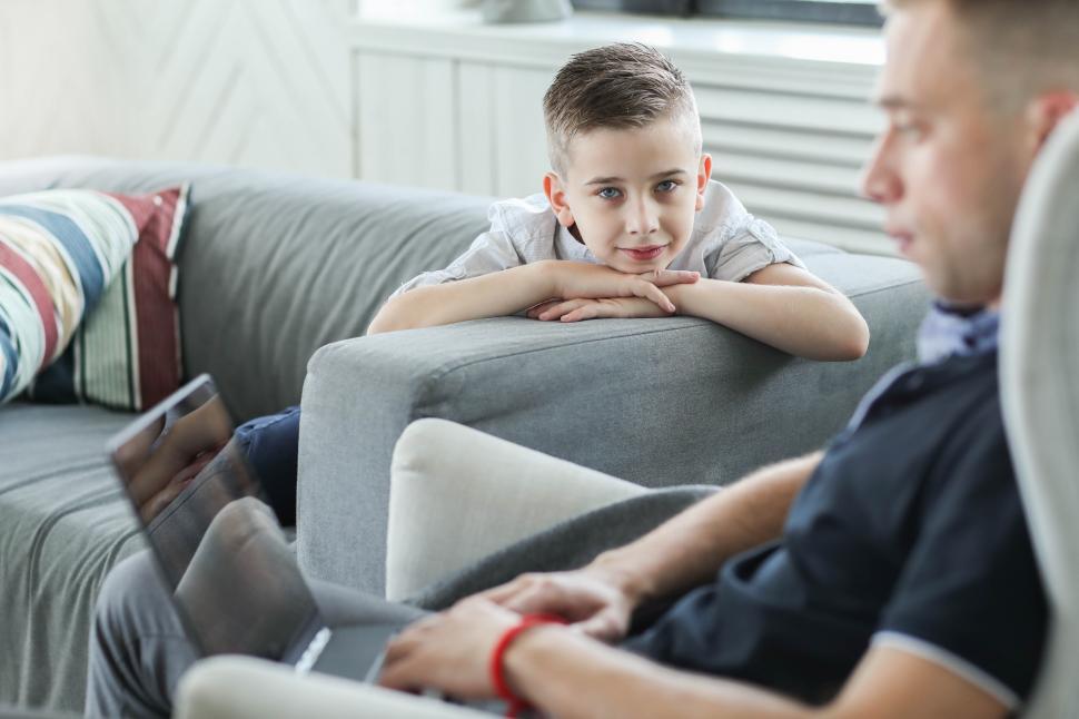 Free Image of Family at home - kid lookin past working dad 