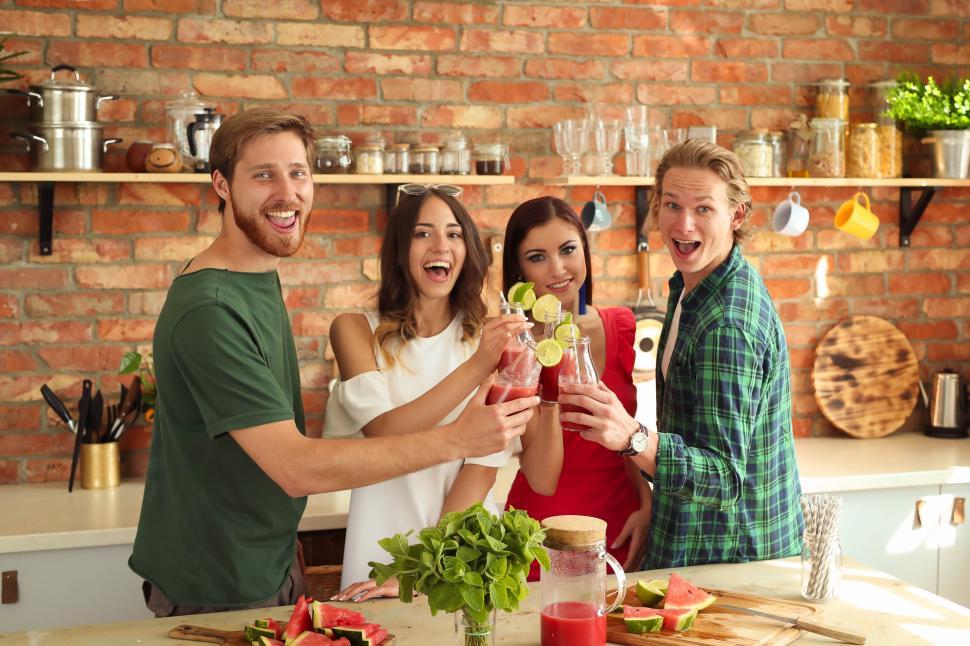 Free Image of Friends toast in the kitchen 