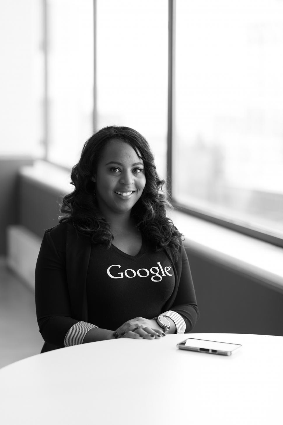 Free Image of Female executive with smartphone on table - smiling for camera 
