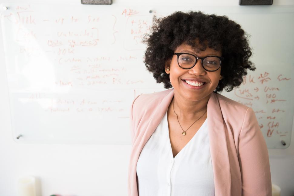 Free Image of Smiling female professional in office - eye contact 