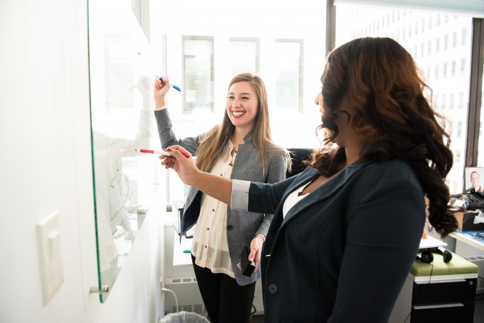 Free Image of Two business women with marker pen and whiteboard 