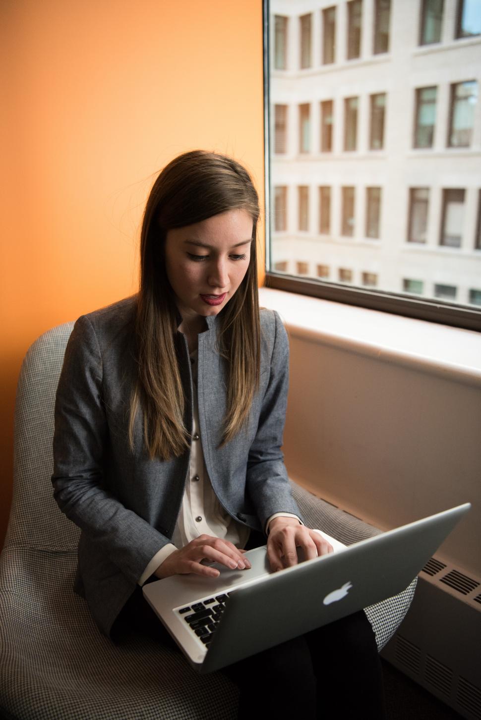 Free Image of Female in formal clothing using laptop near window in office 