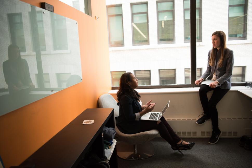 Free Image of Businesswomen with laptop near glass window 