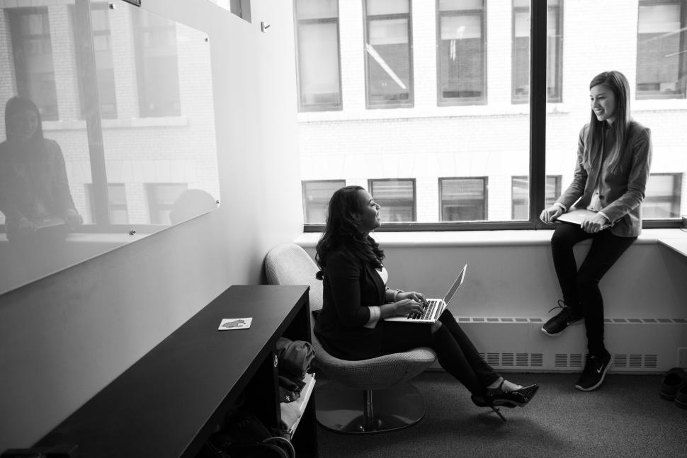 Free Image of Businesswomen with laptop near glass window - b&w 