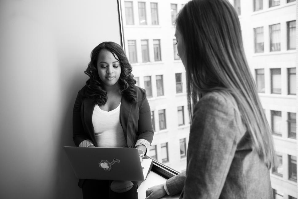 Free Image of Businesswomen with laptop near glass window - b&w 