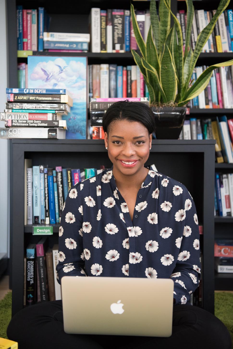 Free Image of Happy female developer with laptop in library 
