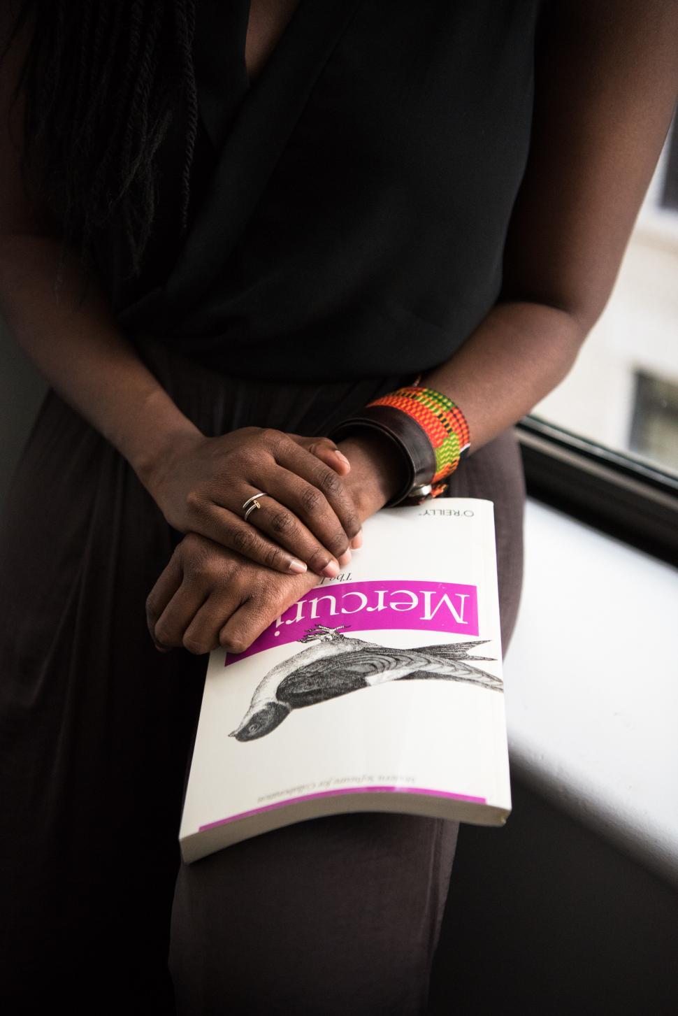 Free Image of Woman hands and book near glass window 