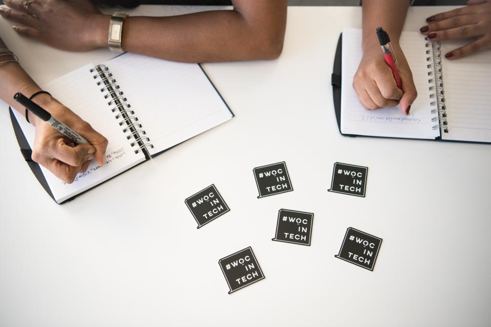 Free Image of Businesswomen writing notes with wocintech logo 