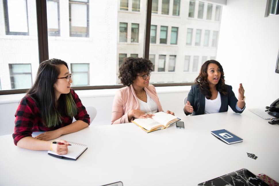 Free Image of Three young female co-workers sitting in meeting room 