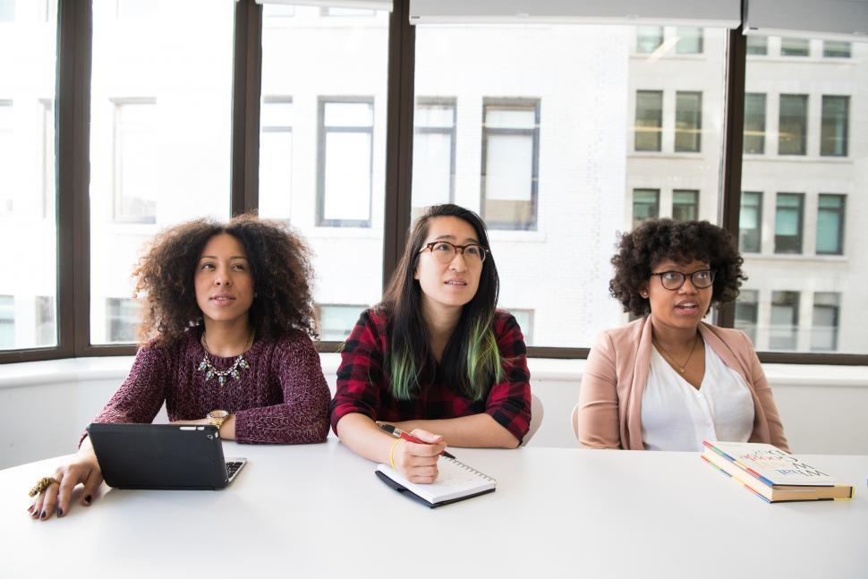 Free Image of Young female co-workers sitting in meeting room 