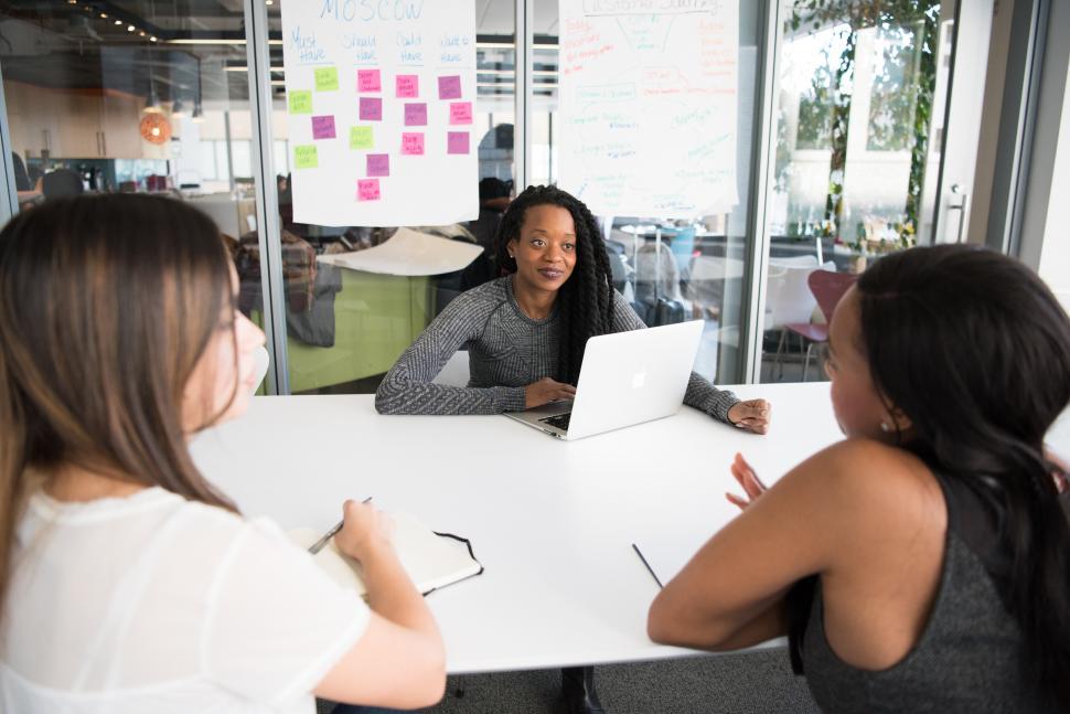 Free Image of Young female co-workers, talking in meeting room 