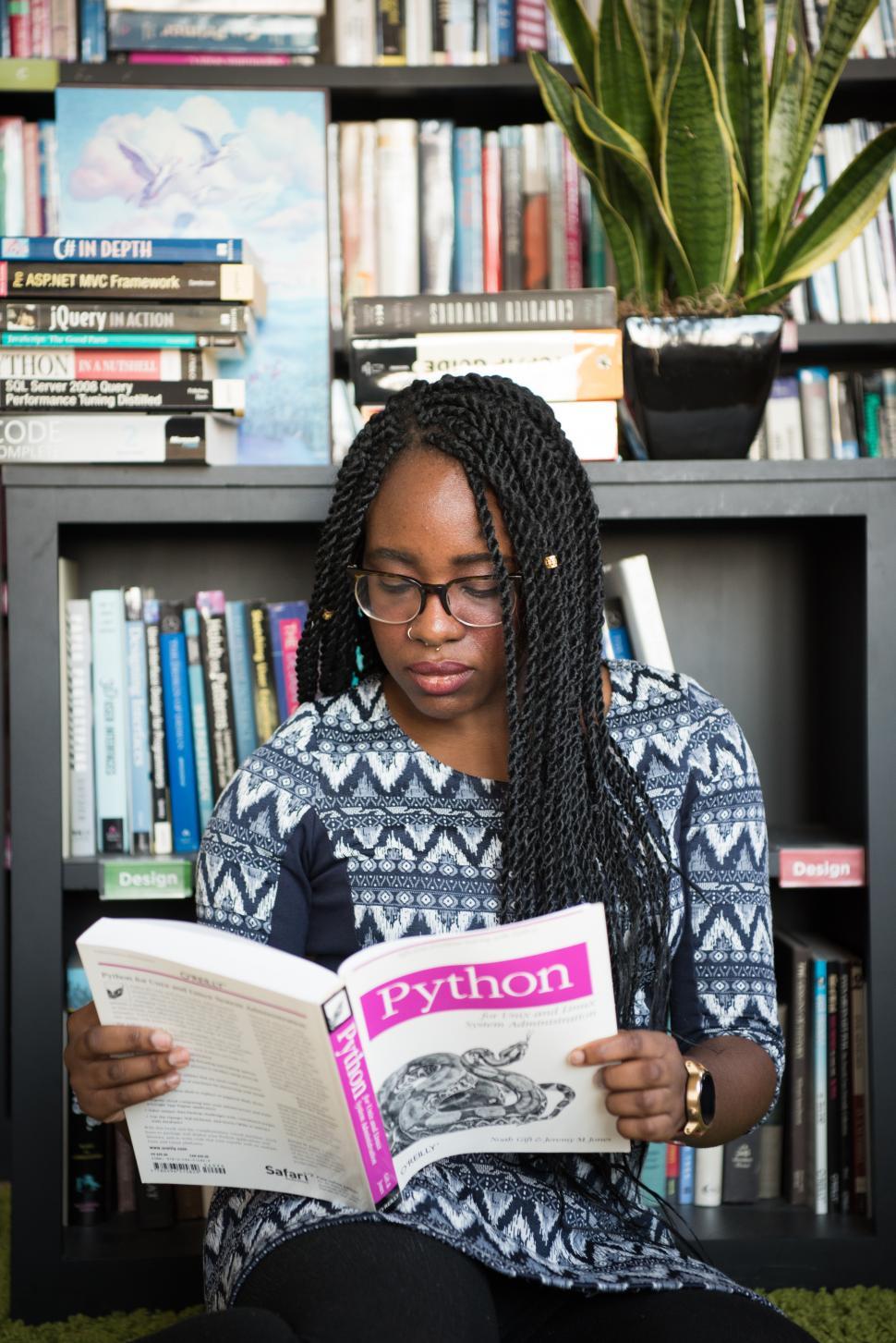 Free Image of Female developer with book in library 