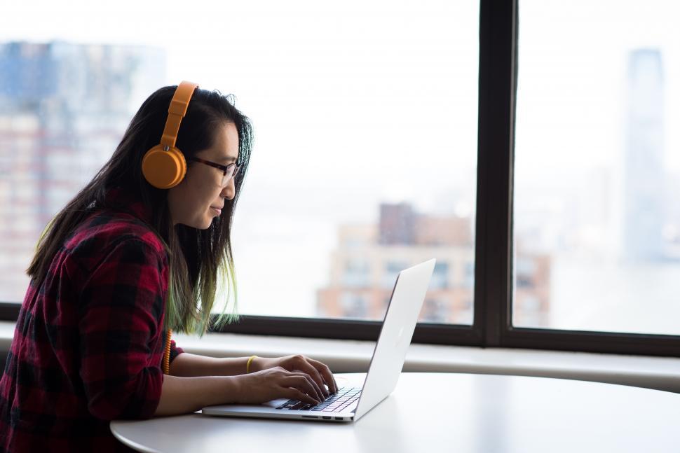 Free Image of Female executive using laptop with headphones in office 