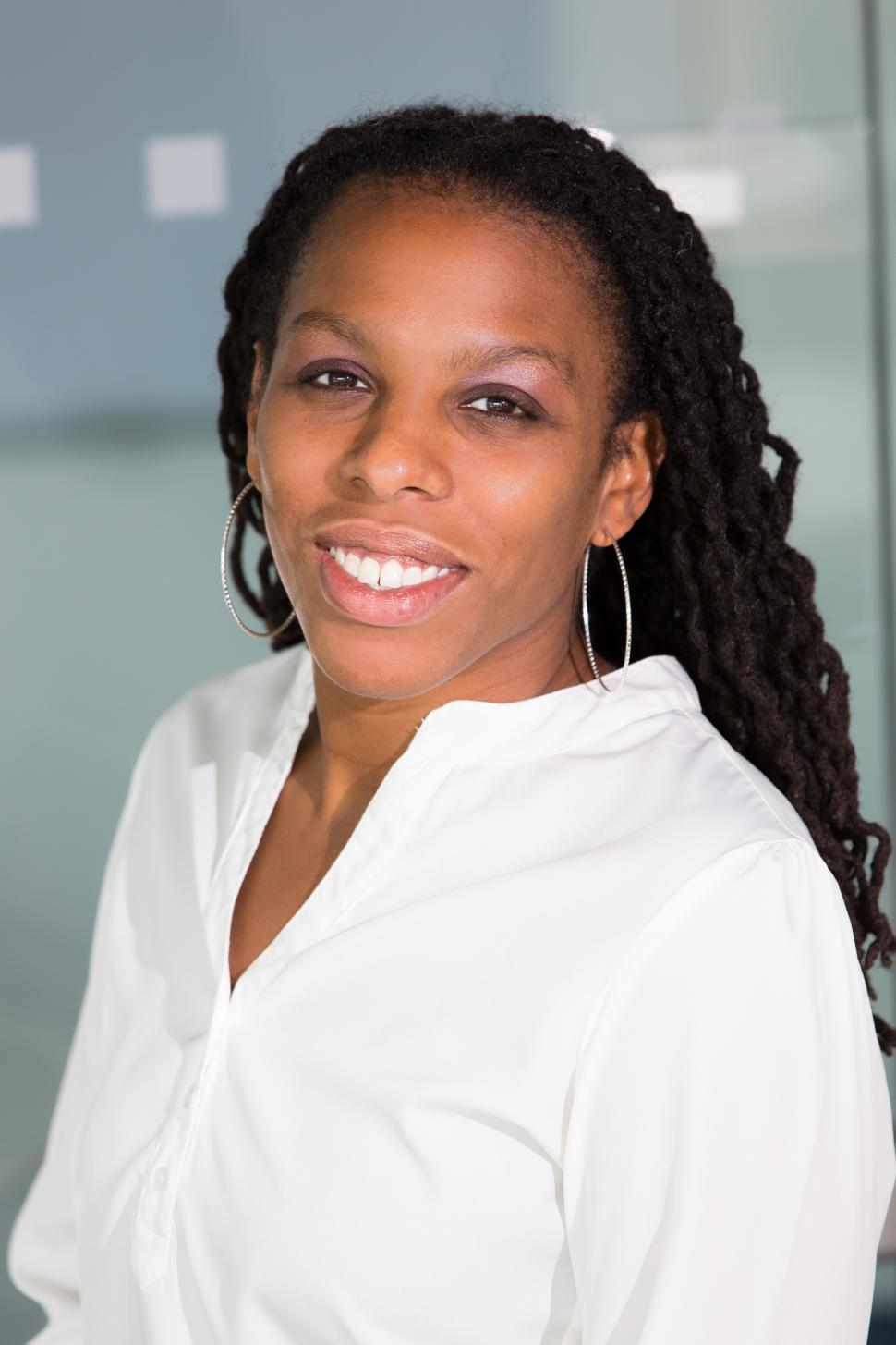 Free Image of Smiling female professional poses for camera in office 