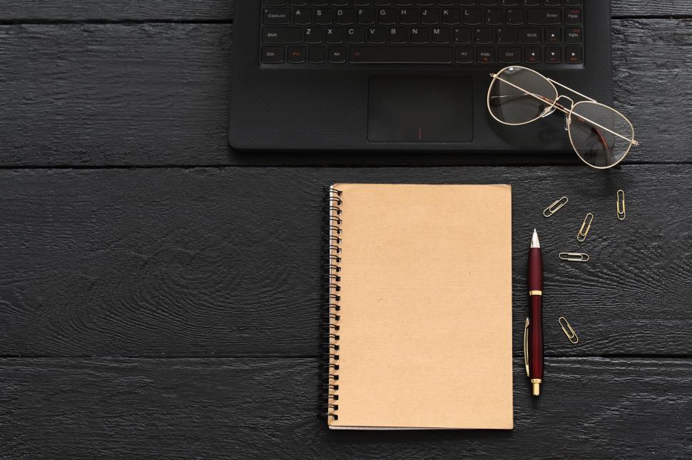 Free Image of Notebook and office items on dark desk 