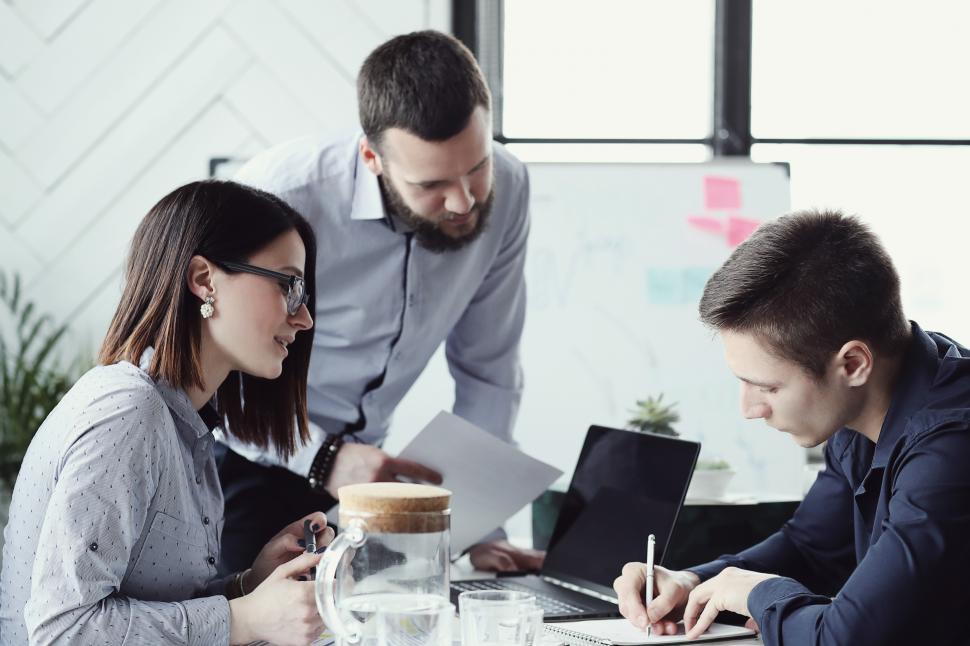 Free Image of Business people gather around a desk 