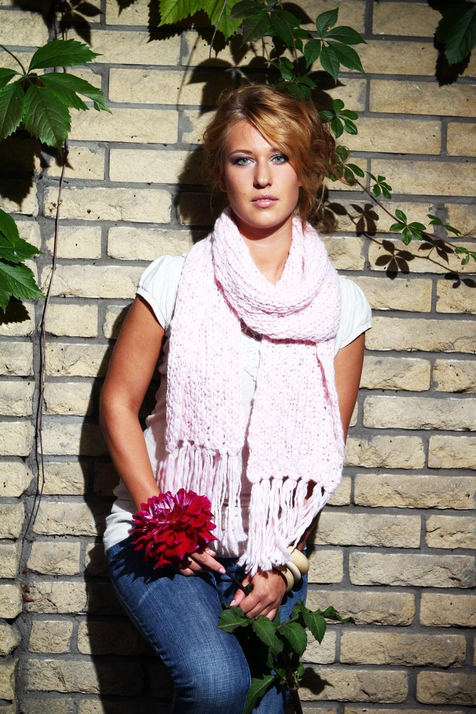 Free Image of Young woman beside a brick wall 