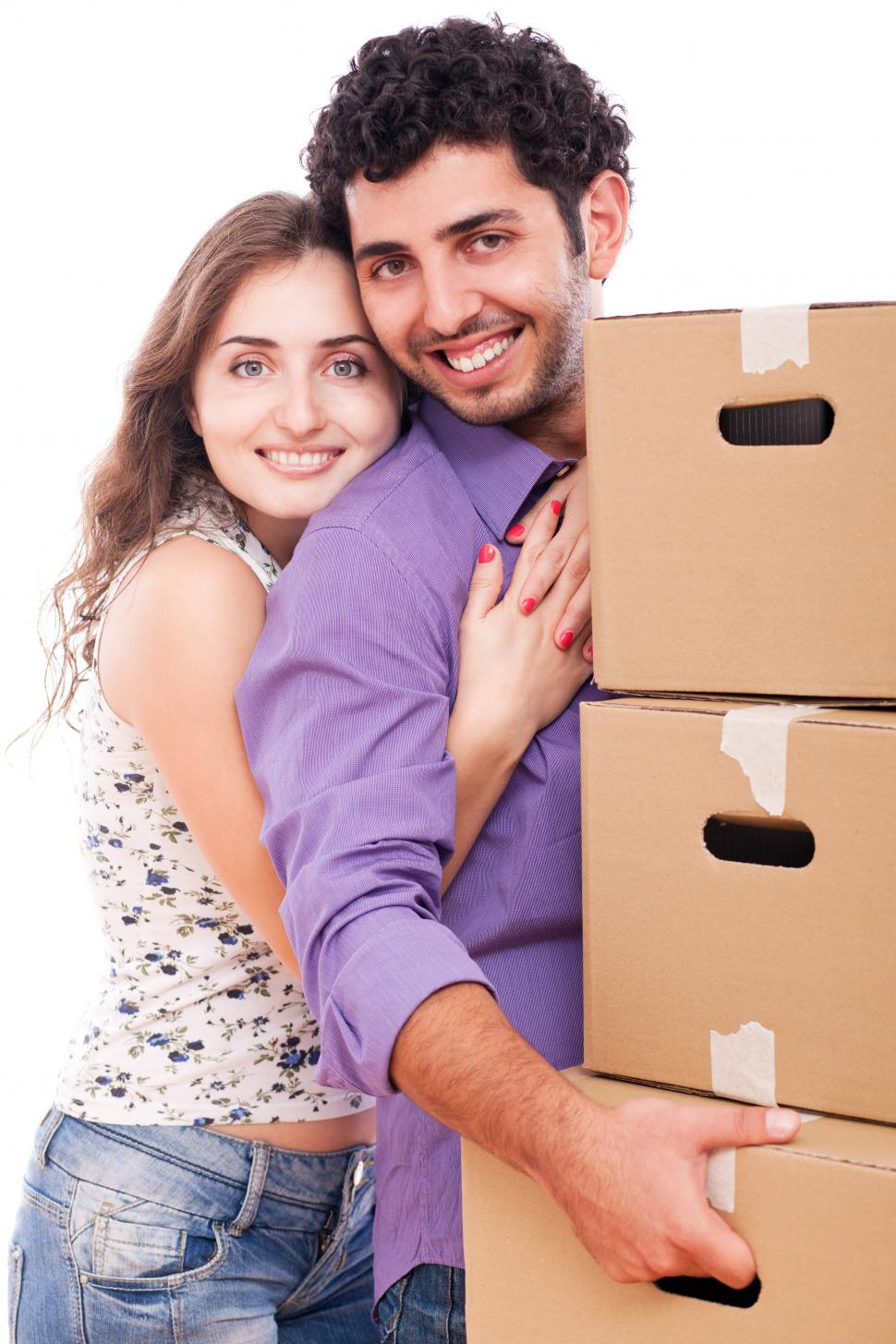 Free Image of Young couple carrying moving boxes 