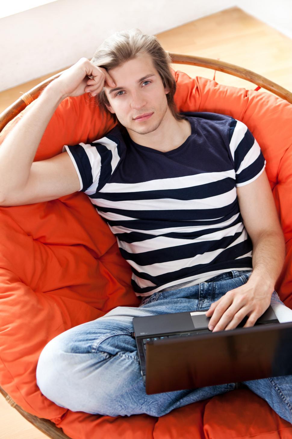 Free Image of Happy handsome guy relaxing in padded chair 