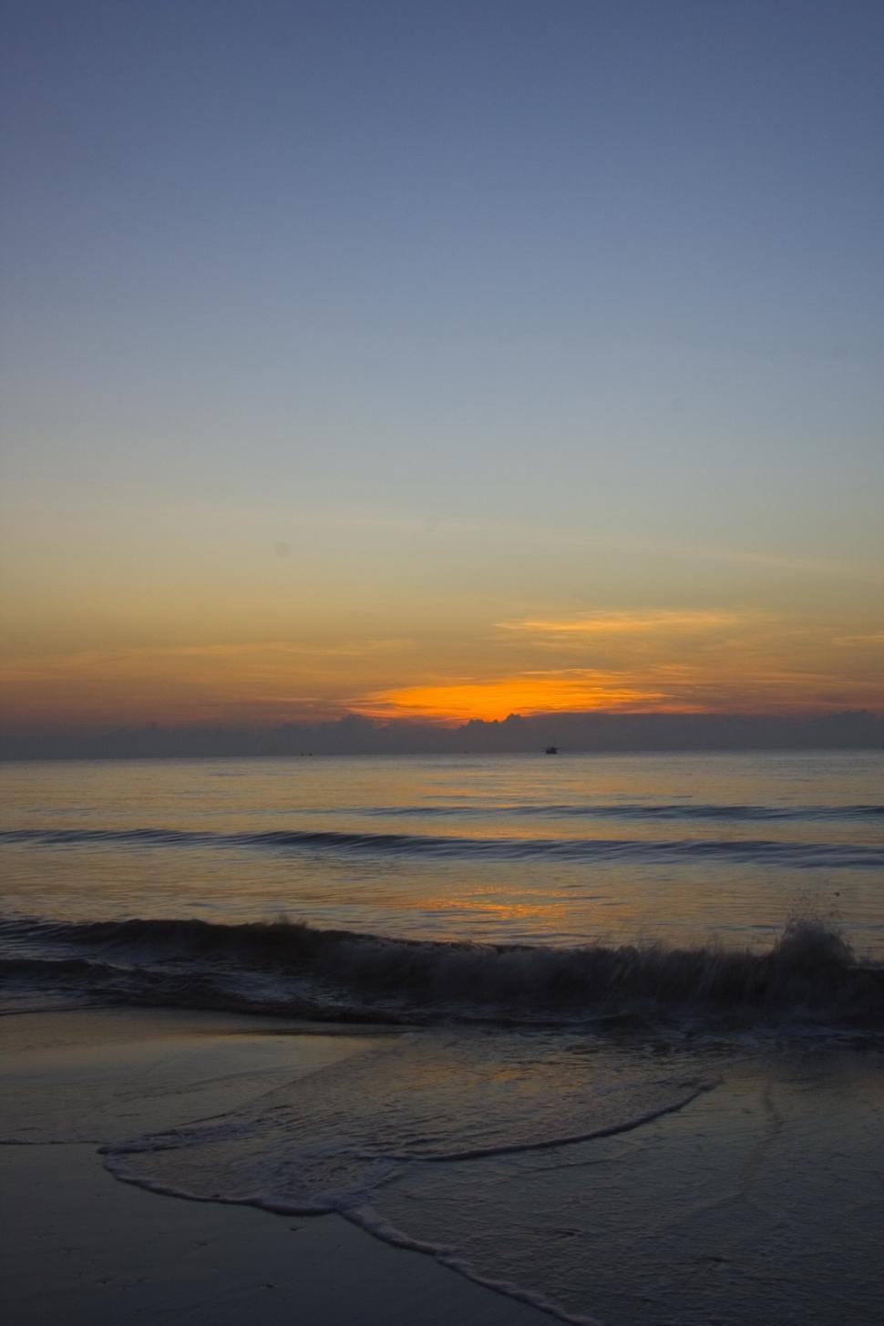 Free Image of Sun Setting Over Ocean on Beach 
