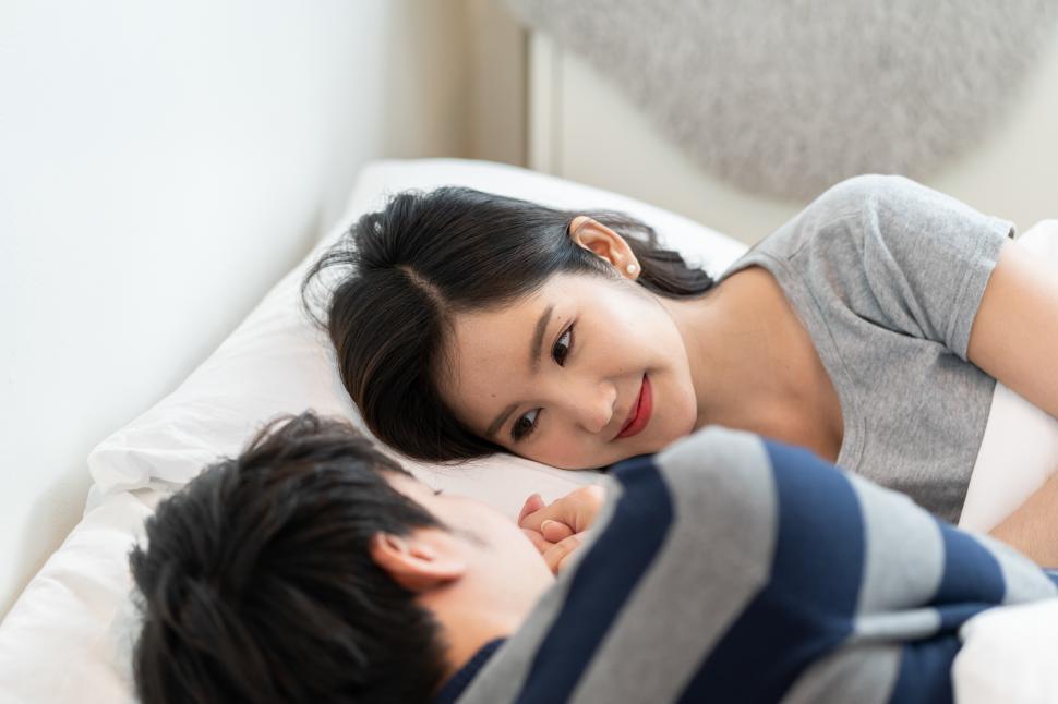 Free Image of young asian couple on bed in bedroom 
