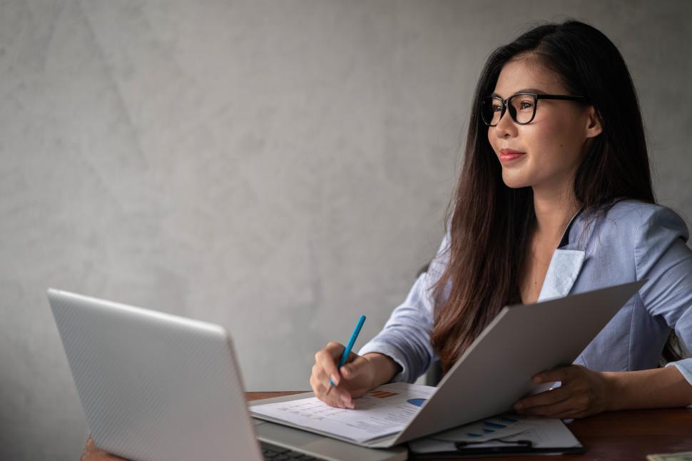 Free Image of Young happy Asian businesswoman in blue shirt working from home 