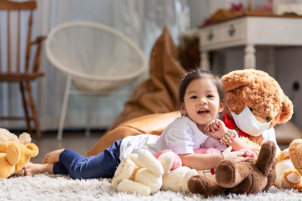 Free Image of A happy asian girl smiling and lying on the floor 